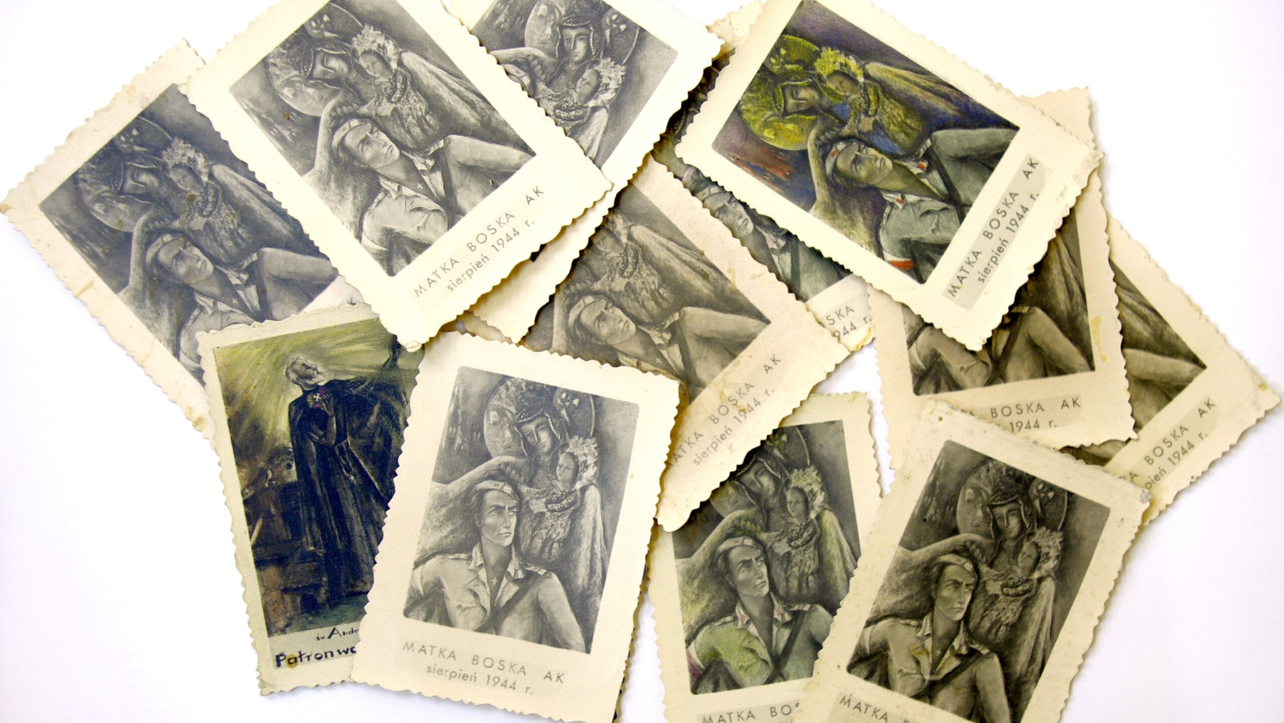 Reprodukcje obrazu „Matka Boska AK” na rozsypanych pocztówkach, pożółkłych, zniszczonych